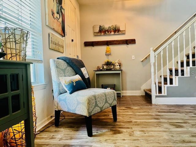 11607 NW 18th Pl, Gainesville, FL 32606 - sitting room featuring baseboards, wood finished floors, stairway, and a healthy amount of sunlight