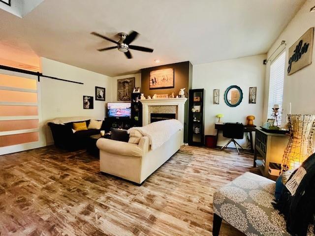 11607 NW 18th Pl, Gainesville, FL 32606 - living room featuring ceiling fan, a barn door, wood finished floors, and a fireplace