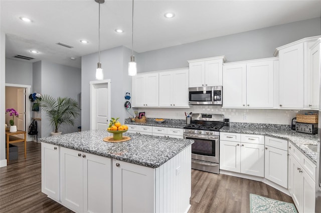 kitchen with stainless steel appliances, decorative light fixtures, a center island, and white cabinets