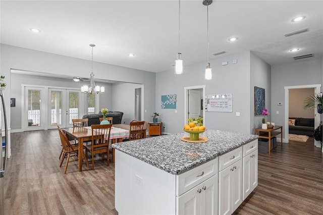 kitchen with white cabinetry, hanging light fixtures, a center island, dark hardwood / wood-style flooring, and french doors
