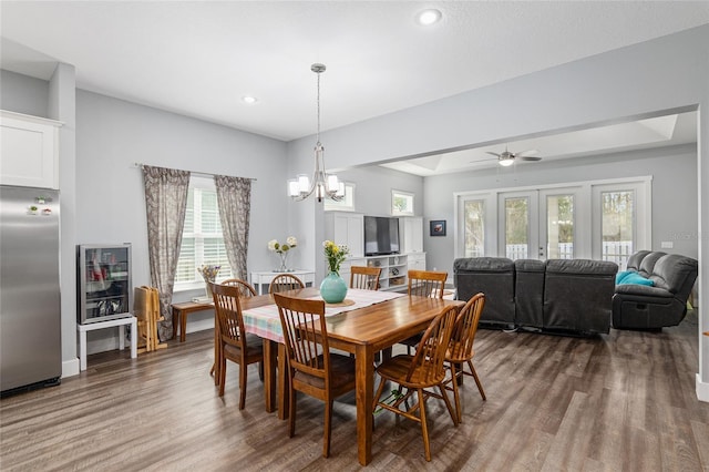 dining room featuring wood-type flooring, a tray ceiling, a chandelier, and french doors