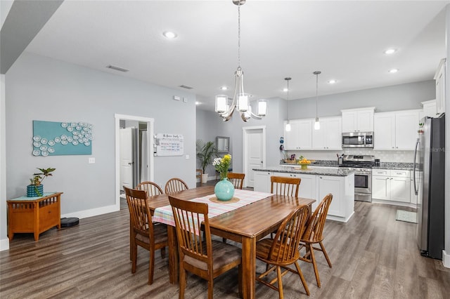 dining area with dark hardwood / wood-style floors and a chandelier