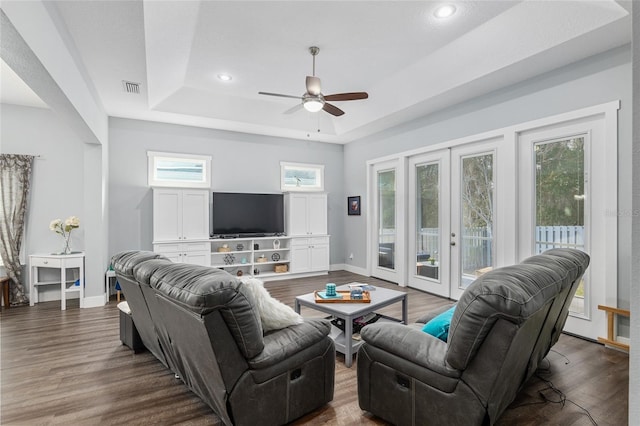 living room featuring french doors, dark hardwood / wood-style floors, ceiling fan, and a tray ceiling