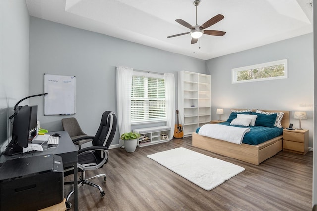 bedroom with ceiling fan, wood-type flooring, and multiple windows