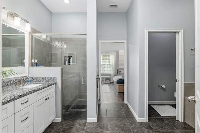bathroom with vanity, a shower with shower door, and toilet