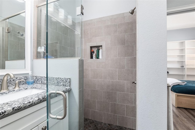 bathroom featuring vanity, a shower with shower door, and wood-type flooring
