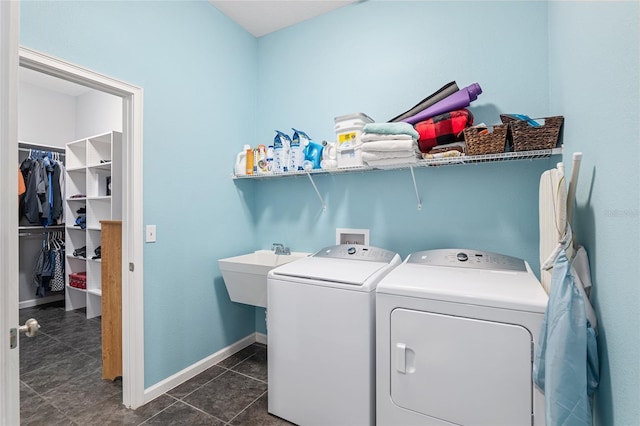 laundry room featuring washer and clothes dryer, sink, and dark tile patterned flooring
