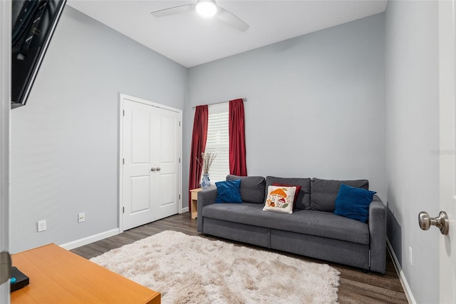 living room with dark hardwood / wood-style flooring and ceiling fan