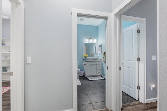 hall featuring dark tile patterned floors