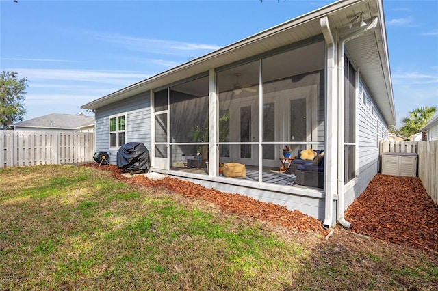 rear view of house with a lawn and a sunroom