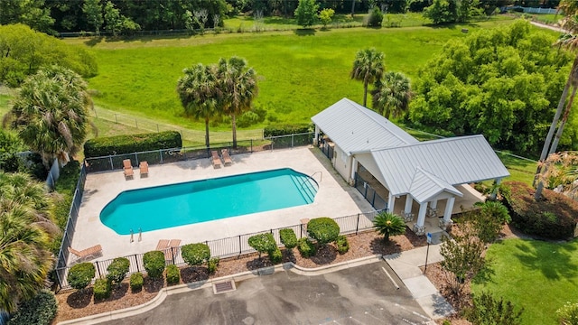 view of pool with a lawn and a patio