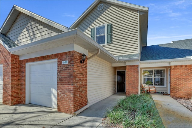 exterior space with a garage, brick siding, and a shingled roof