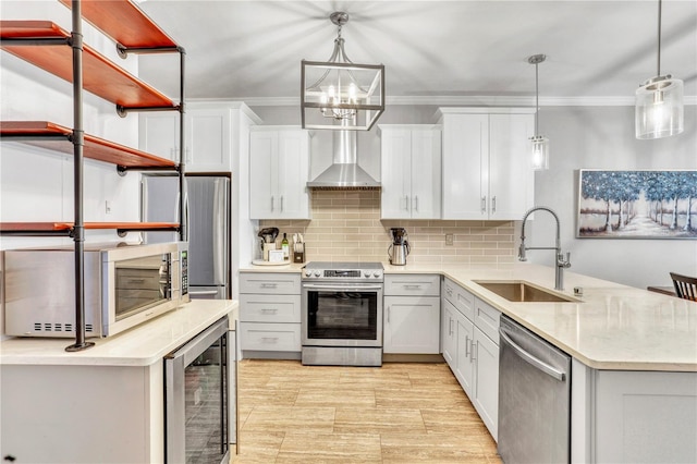 kitchen featuring wine cooler, stainless steel appliances, a sink, a peninsula, and wall chimney exhaust hood