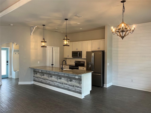 kitchen featuring arched walkways, stainless steel appliances, visible vents, a sink, and a peninsula