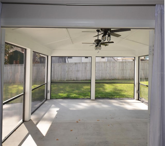 unfurnished sunroom featuring lofted ceiling with beams and a ceiling fan