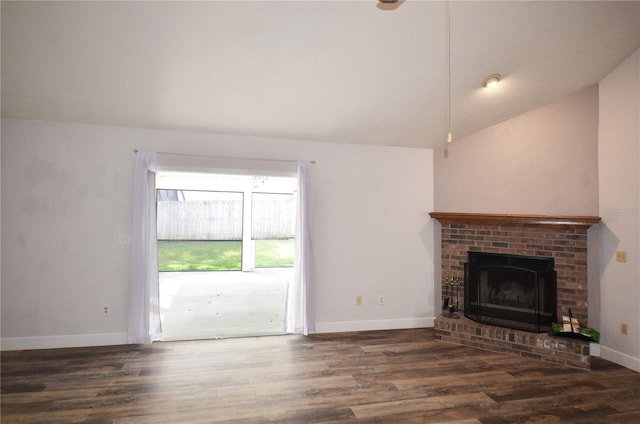 unfurnished living room featuring dark wood finished floors, a brick fireplace, vaulted ceiling, and baseboards