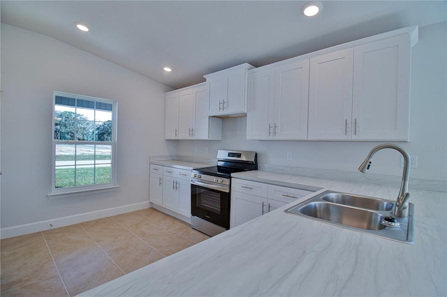 kitchen with stainless steel electric stove, vaulted ceiling, white cabinetry, a sink, and light tile patterned flooring