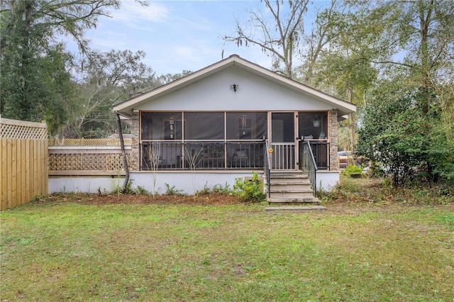 back of house with a yard and a sunroom