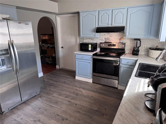 kitchen featuring dark hardwood / wood-style flooring, sink, decorative backsplash, and appliances with stainless steel finishes