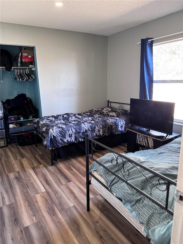 bedroom featuring wood-type flooring and a textured ceiling