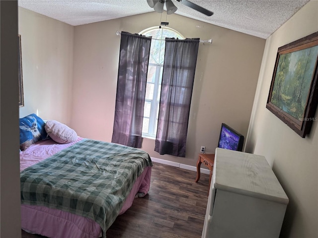 bedroom with multiple windows, lofted ceiling, dark hardwood / wood-style floors, and a textured ceiling