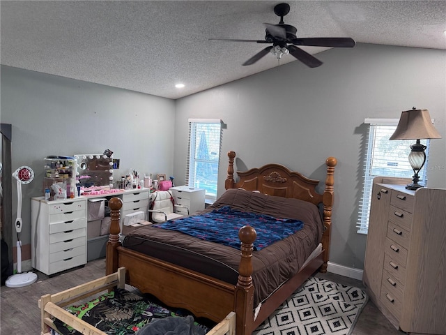 bedroom with lofted ceiling, ceiling fan, light hardwood / wood-style floors, and a textured ceiling