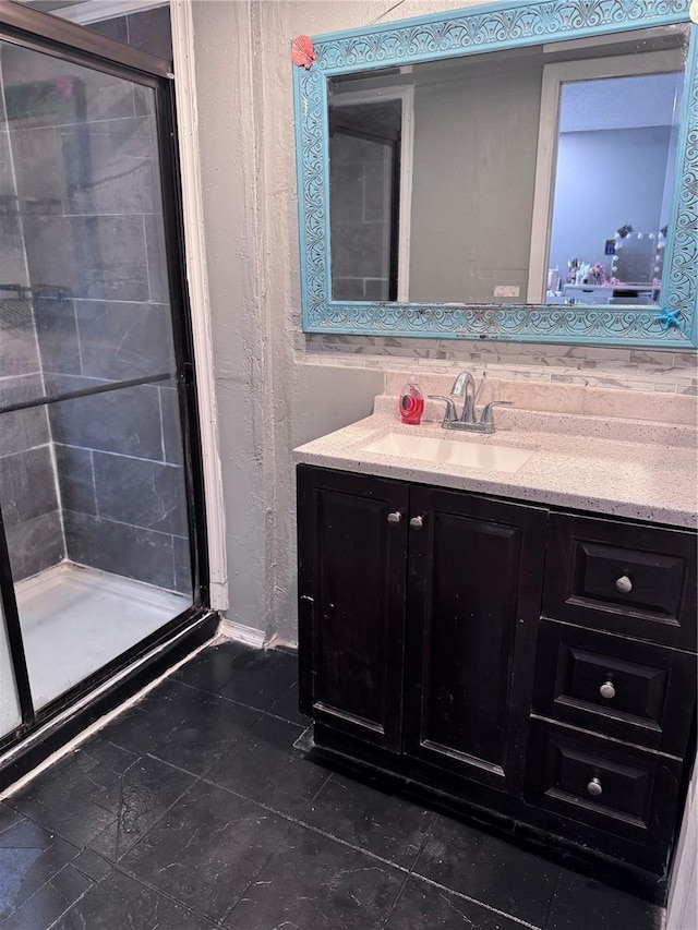 bathroom featuring a shower with door and vanity