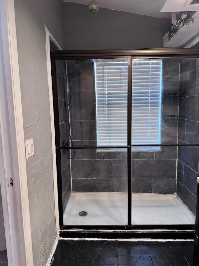 bathroom featuring a shower with shower door