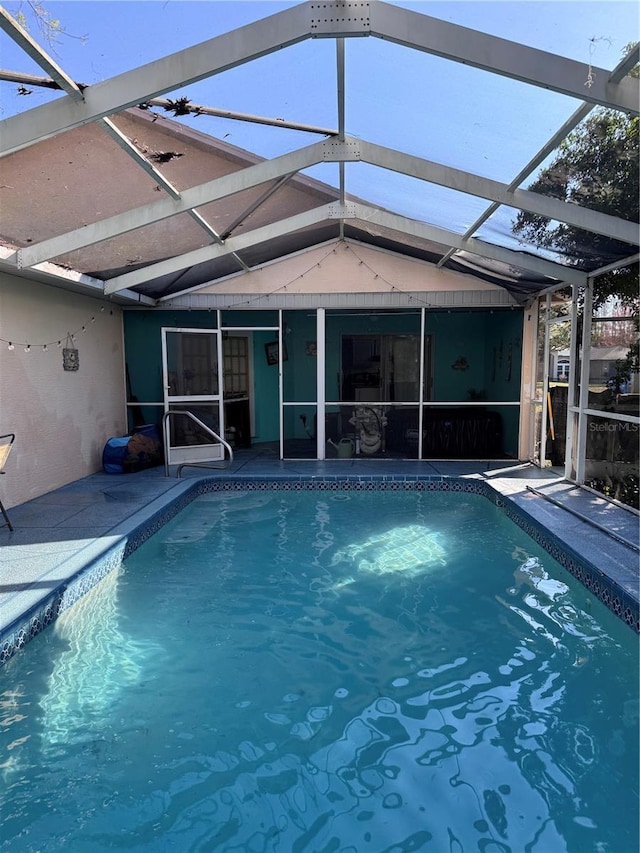 view of pool featuring glass enclosure