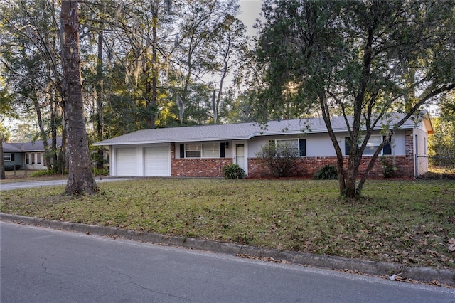 single story home featuring a garage and a front yard