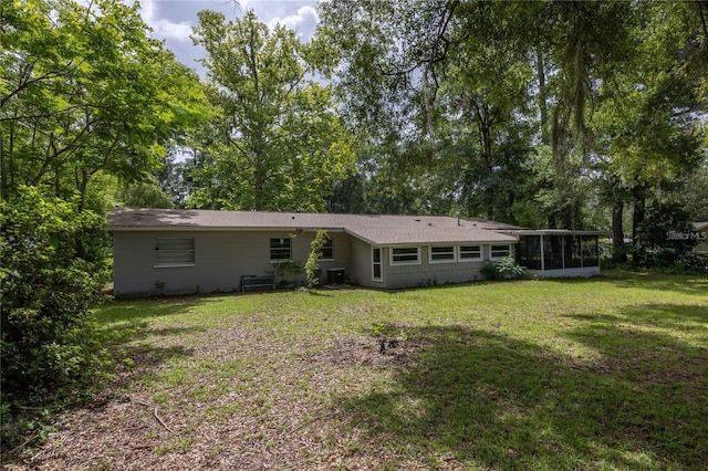 back of house with a yard and a sunroom