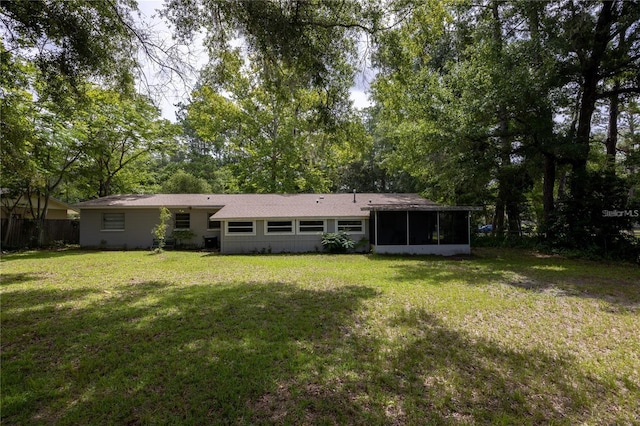 back of property with a yard and a sunroom