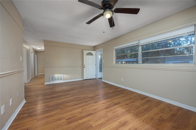 spare room with wood-type flooring, ceiling fan, and a textured ceiling