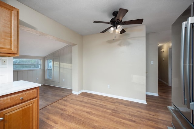 interior space with lofted ceiling, hardwood / wood-style floors, a textured ceiling, and ceiling fan