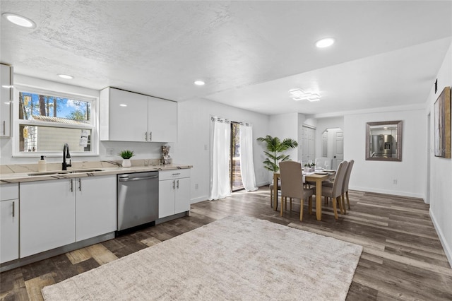 kitchen featuring sink, a textured ceiling, stainless steel dishwasher, dark hardwood / wood-style floors, and white cabinets