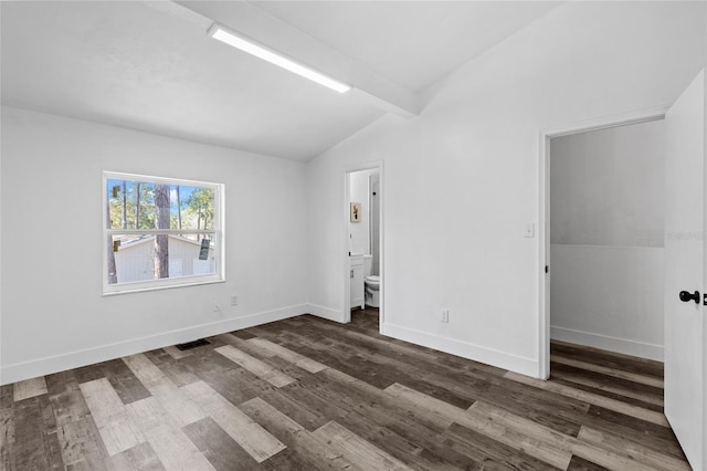 spare room featuring dark hardwood / wood-style flooring and lofted ceiling with beams