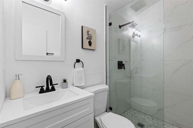 bathroom with vanity, a shower with shower door, and toilet