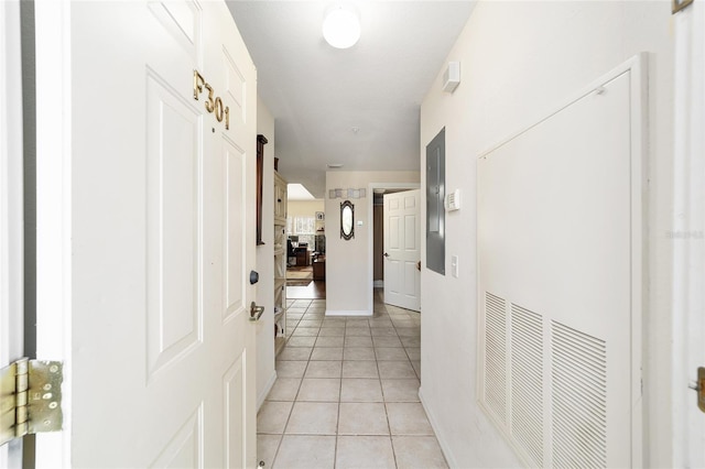 hall featuring light tile patterned floors and a barn door