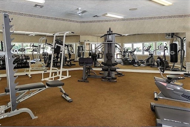 exercise room with carpet floors and a textured ceiling