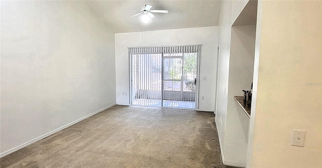 carpeted spare room with lofted ceiling, ceiling fan, and baseboards