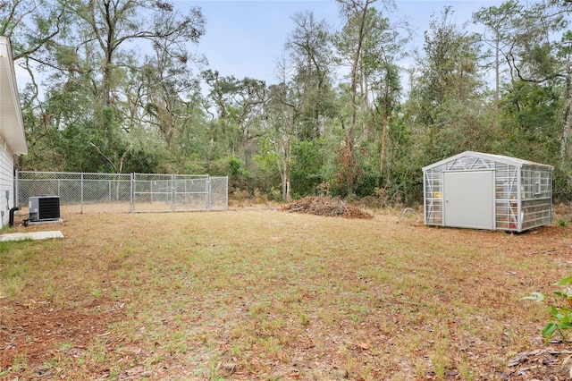 view of yard featuring central AC unit and a storage unit