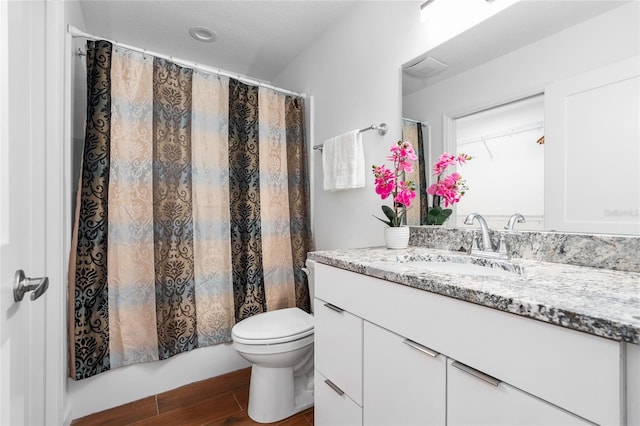 bathroom with vanity, hardwood / wood-style floors, walk in shower, and toilet