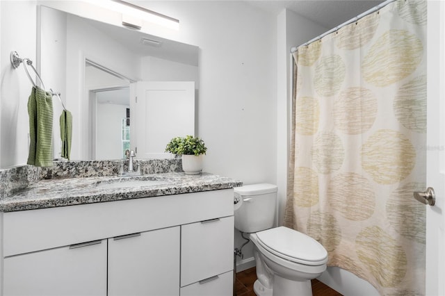 bathroom featuring a shower with curtain, vanity, and toilet