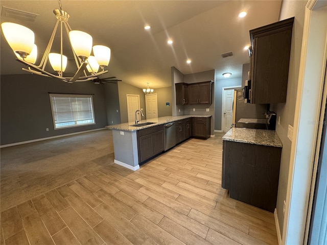 kitchen featuring light stone counters, a notable chandelier, decorative light fixtures, and sink