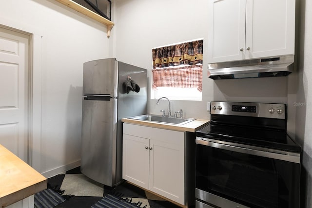 kitchen with under cabinet range hood, white cabinets, stainless steel appliances, and a sink