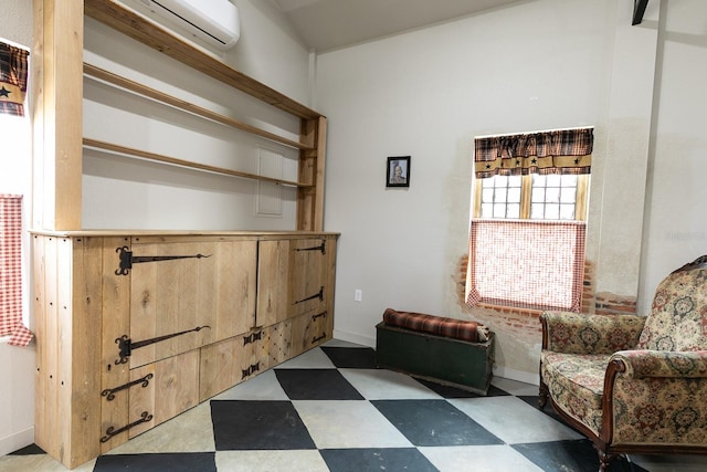 sitting room featuring tile patterned floors, baseboards, and a wall mounted AC