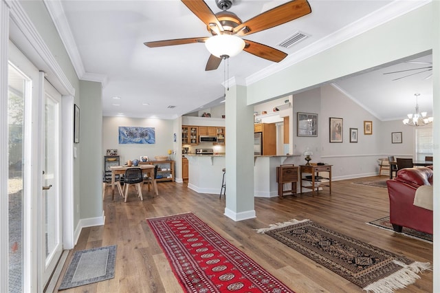 living room with hardwood / wood-style flooring, ornamental molding, and ceiling fan with notable chandelier