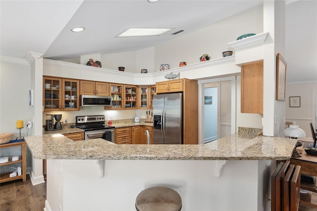 kitchen featuring light stone counters, a breakfast bar area, kitchen peninsula, and appliances with stainless steel finishes