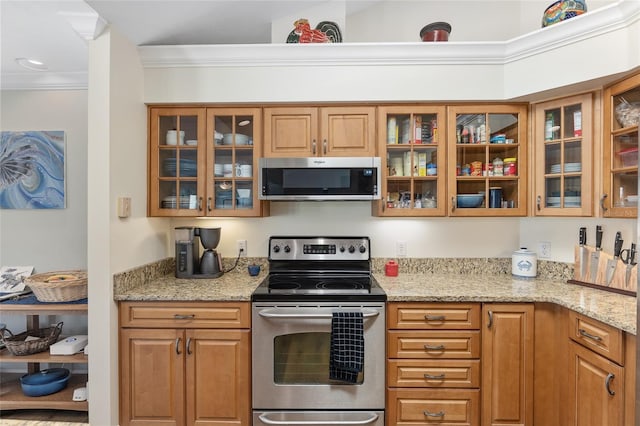 kitchen with stainless steel appliances, crown molding, and light stone countertops