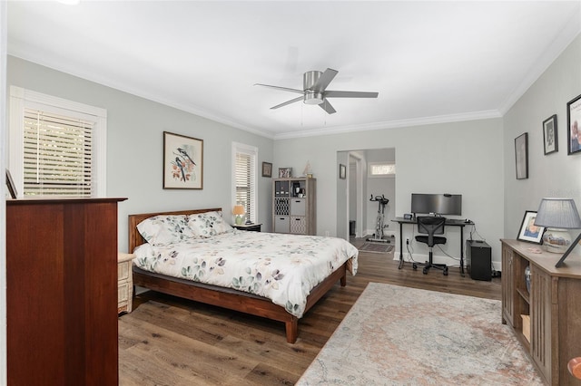 bedroom featuring multiple windows, dark wood-type flooring, ornamental molding, and ceiling fan